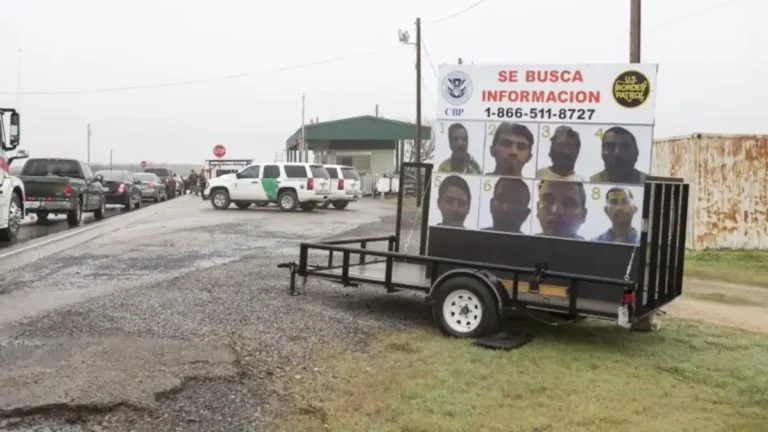Remolque con cartel móvil de “Se Busca Información” y fotos de buscados instalado junto a una carretera.